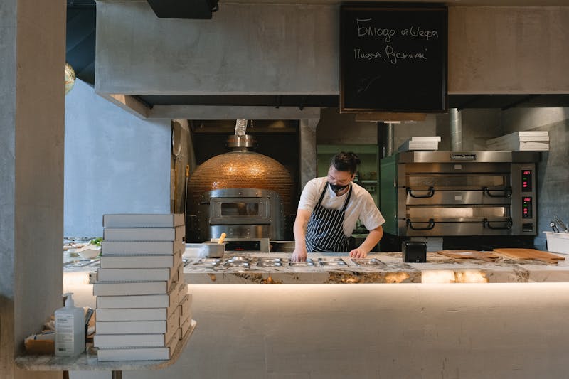 Pizza dough being kneaded by hand in a professional kitchen